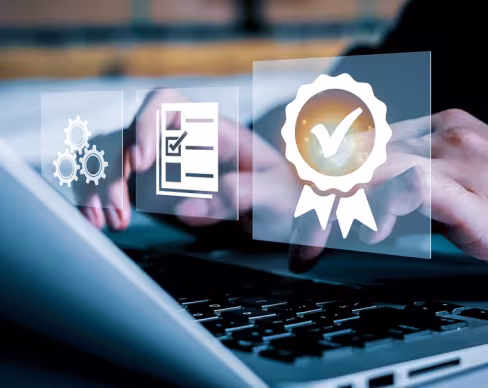 Close-up of hands typing on a laptop keyboard, with floating icons representing quality management concepts.